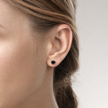 woman wearing black moissanite stud earrings