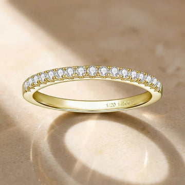 Moissanite stackable ring in 14K gold filled, a thin half eternity band of prong-set stones with the 1/20 14K GF stamp inside, on a warm stone surface - Sensitive Stones