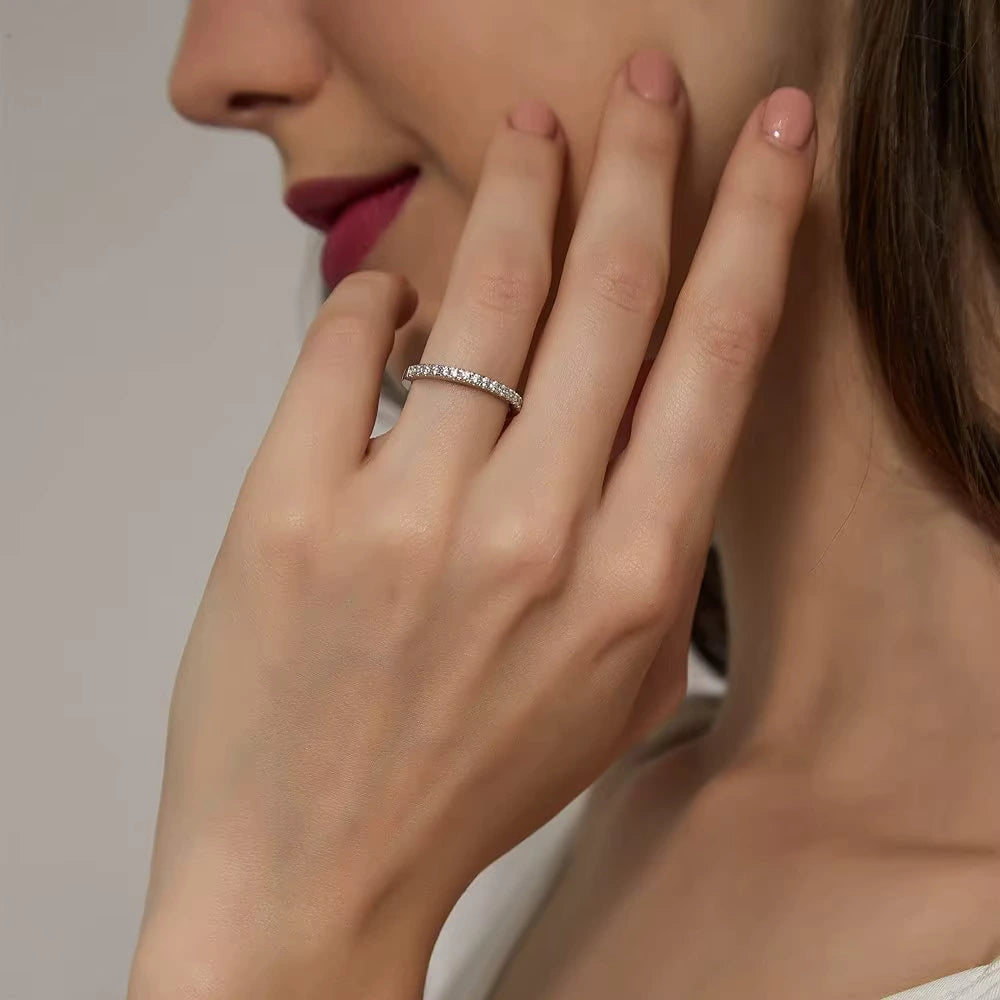 Elegant woman wearing 1.86 CT Moissanite Eternity Ring on her finger, highlighting the minimalist sparkle of the sterling silver band.