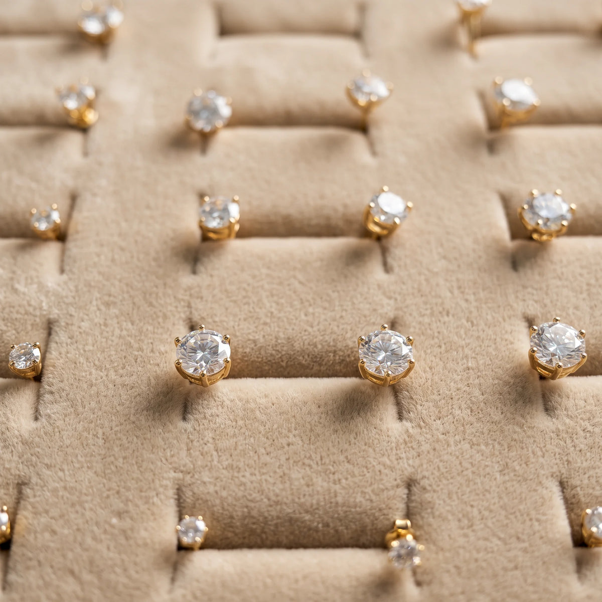 14K gold filled moissanite solitaire stud earrings in yellow gold arranged on a velvet jewelry display pad - Sensitive Stones