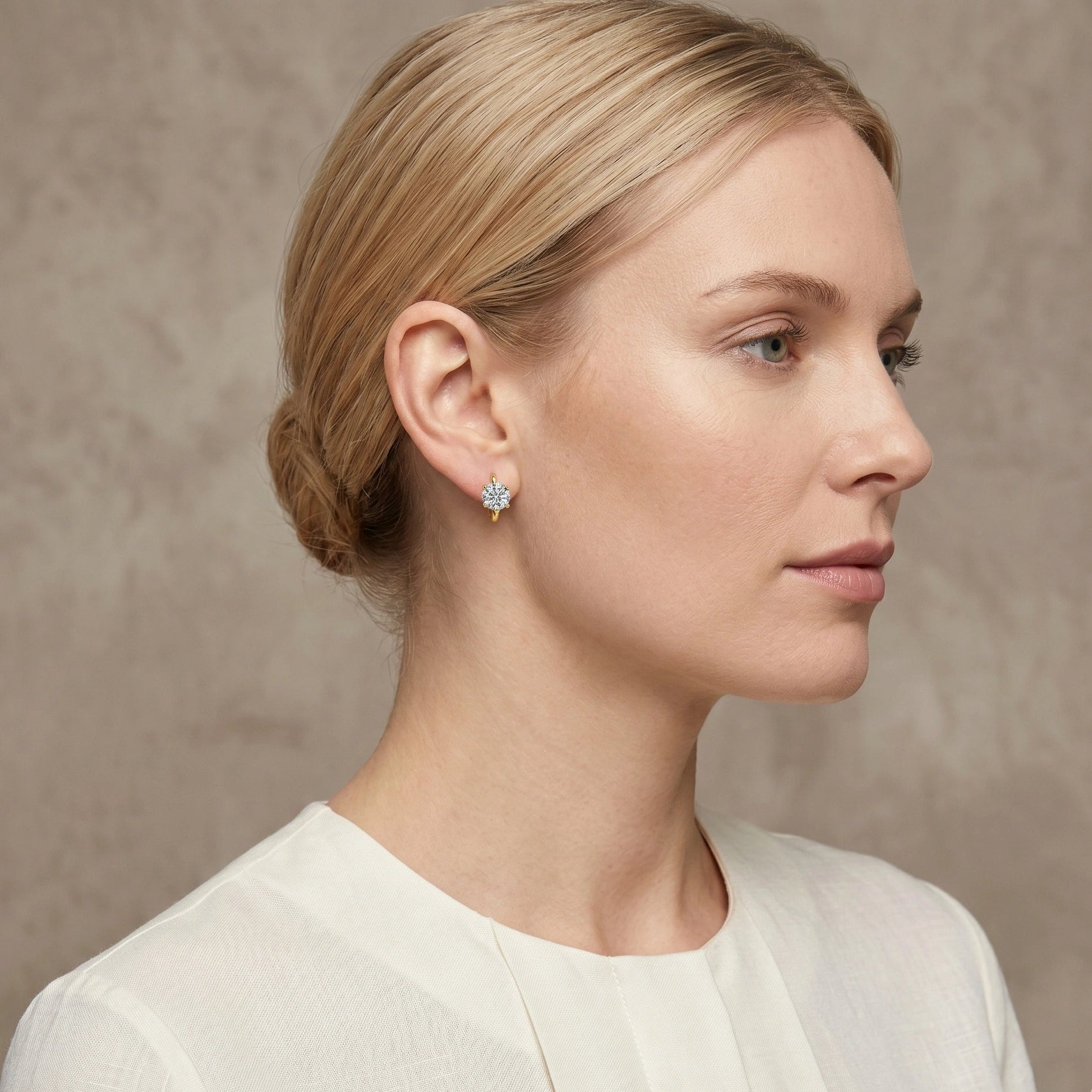 14K gold filled moissanite huggie hoop earring in yellow gold, 1ct round brilliant D color VVS1, worn on ear - Sensitive Stones