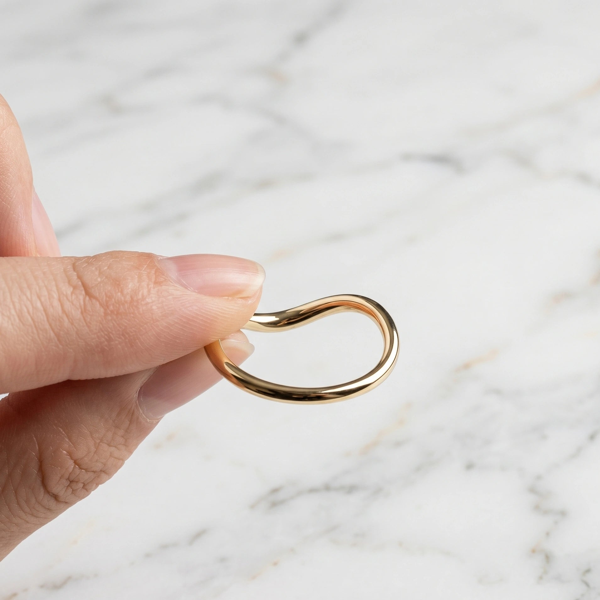 14K gold filled wave stacking ring held between fingers showing asymmetric band profile - Sensitive Stones