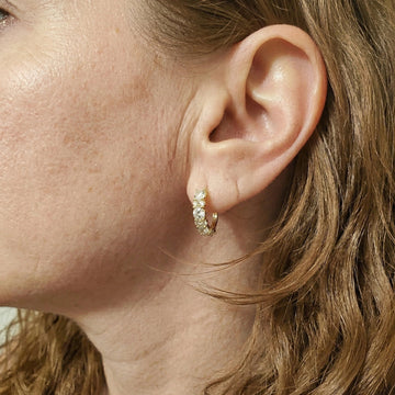 Close-up of a woman wearing a 925 silver moissanite hoop earrings in 18k gold plating - Sensitive Stones