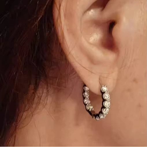 Model wearing 2.6 CT moissanite small hoop earrings in 18K yellow gold plating, highlighting the brilliant shine close-up.