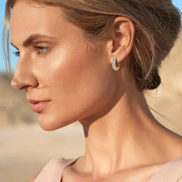 A woman wearing 2.76 CT moissanite small hoop earrings in 18K gold finish, glowing in natural light that highlights their refined sparkle – Sensitive Stones