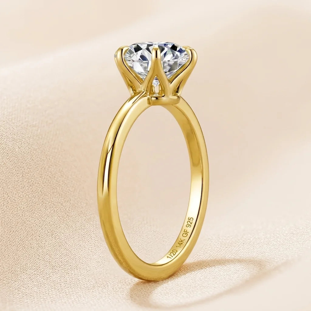 Close up of a 2ct oval moissanite engagement ring in 14K gold filled held between fingertips