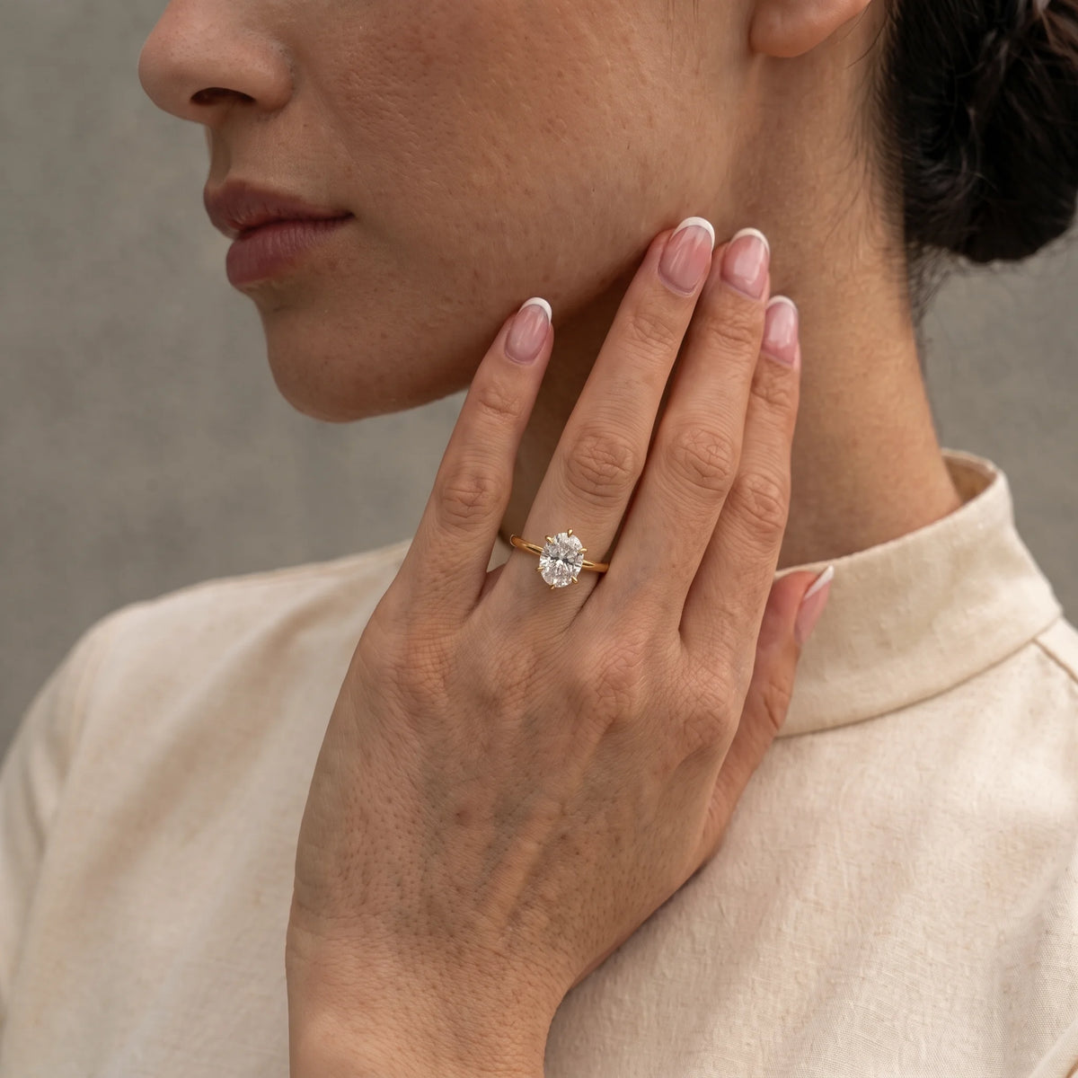 Woman wearing a 2ct oval moissanite engagement ring in 14K gold filled on her ring finger - Sensitive Stones