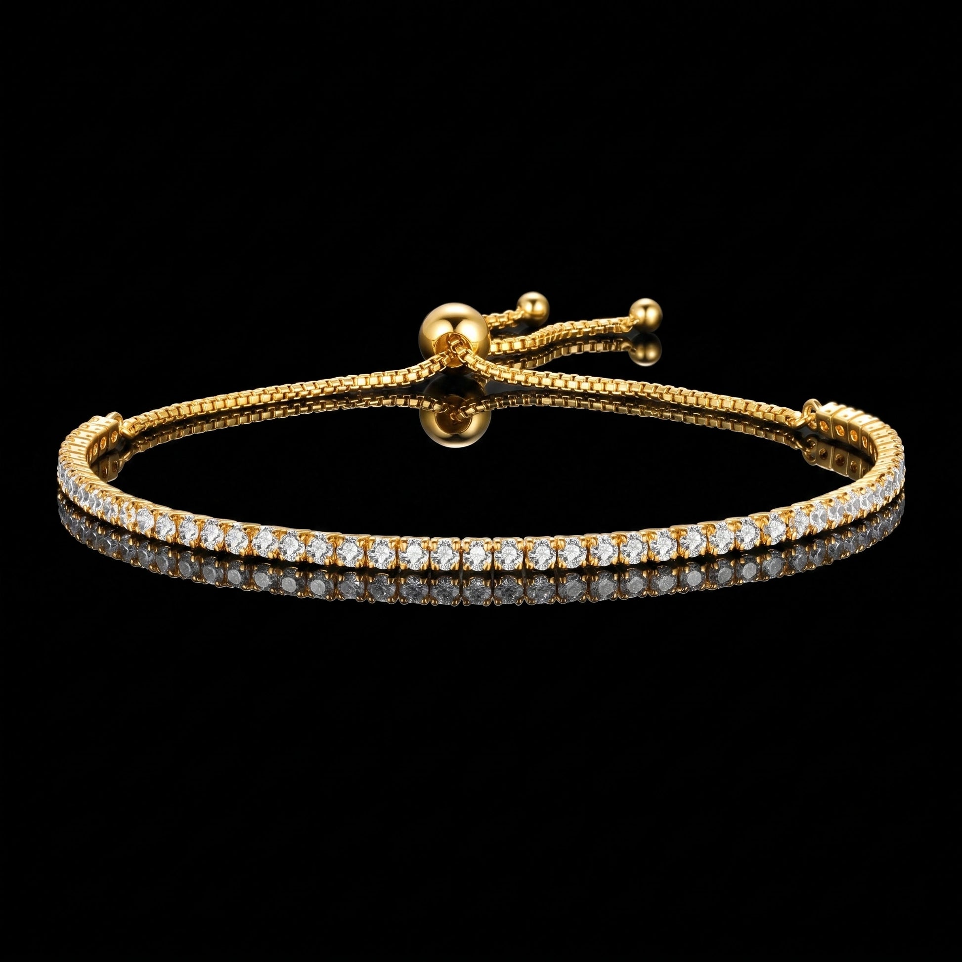 A 2mm moissanite bolo tennis bracelet with clear round-cut stones in 925 sterling silver with a yellow gold finish and sliding bolo closure, on a reflective black background - Sensitive Stones