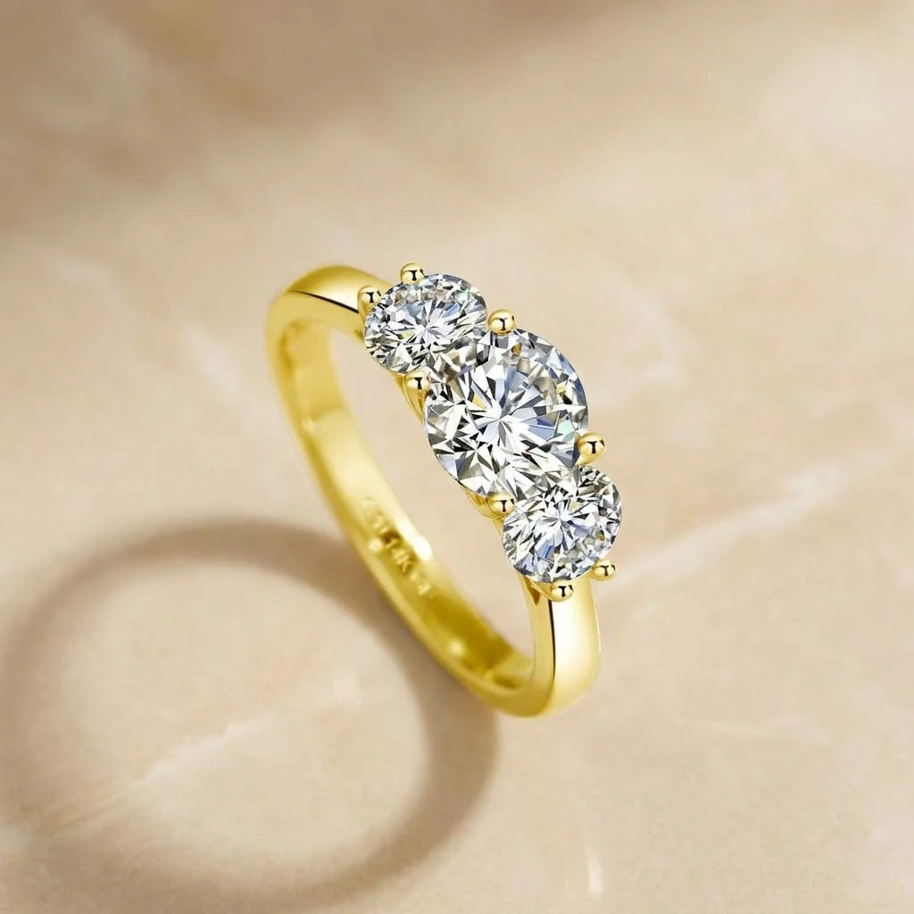 3 stone moissanite engagement ring in 14K gold filled on a stone surface, three D color VVS1 stones - Sensitive Stones