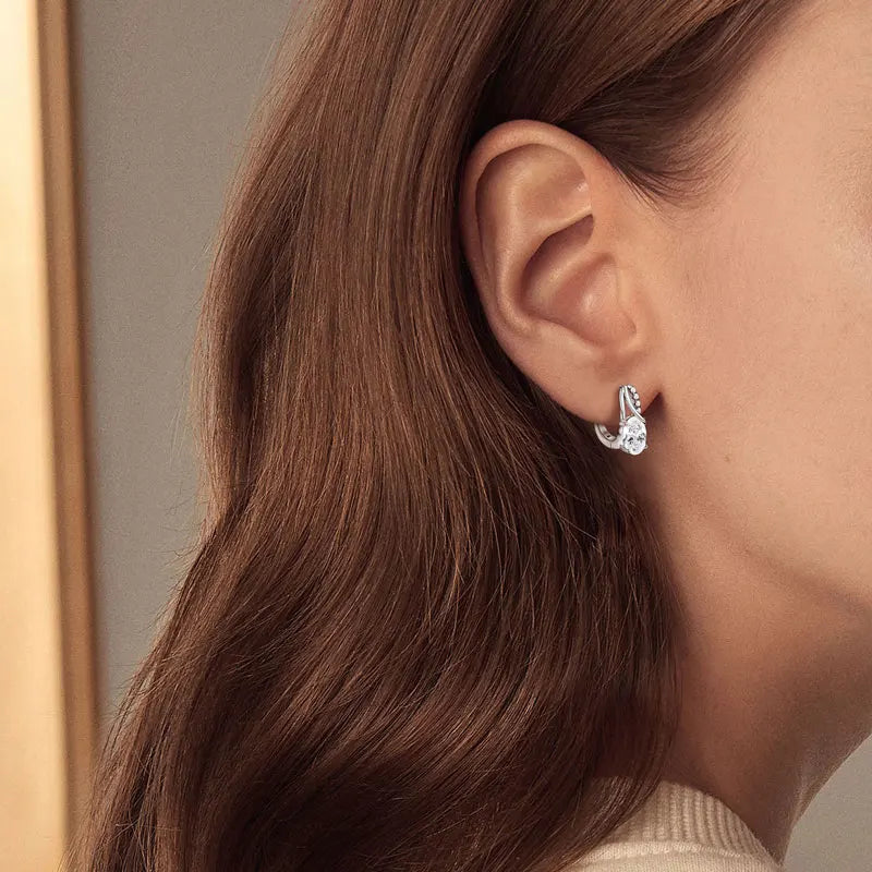 Model wearing 3CT oval Moissanite Huggie hoop earrings in 925 sterling silver - Sensitive Stones