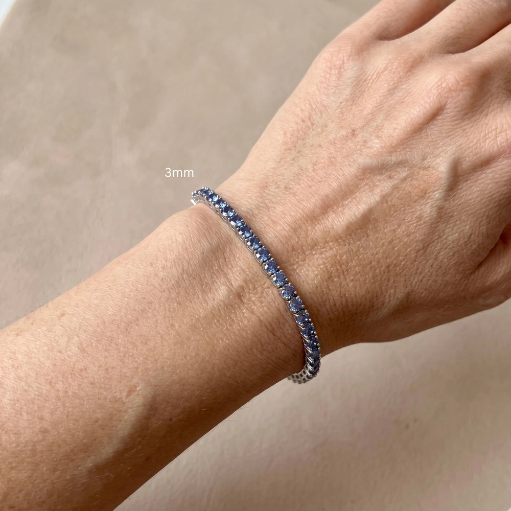 Man wearing 3mm blue moissanite tennis bracelet 925 sterling silver round-cut stones casual lifestyle - Sensitive Stones