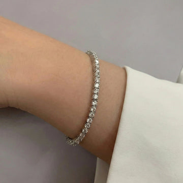 Dainty 3mm cubic zirconia Tennis Bracelet on wrist in 925 sterling silver with white gold finish, worn with an elegant white top - Sensitive Stones
