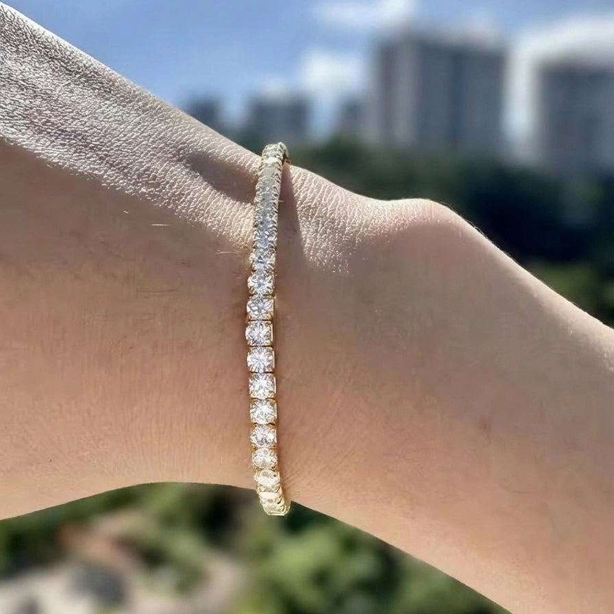 Hand wearing a 3mm yellow gold stretch moissanite tennis bracelet with an elastic fit in 925 sterling silver - Sensitive Stones