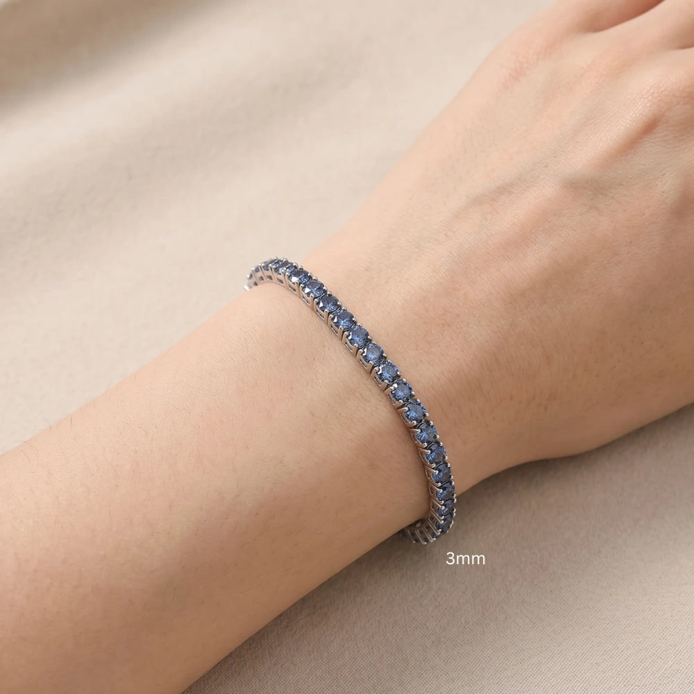 Woman wearing delicate 3mm alternating blue and white moissanite tennis bracelet 925 sterling silver round-cut stones - Sensitive Stones