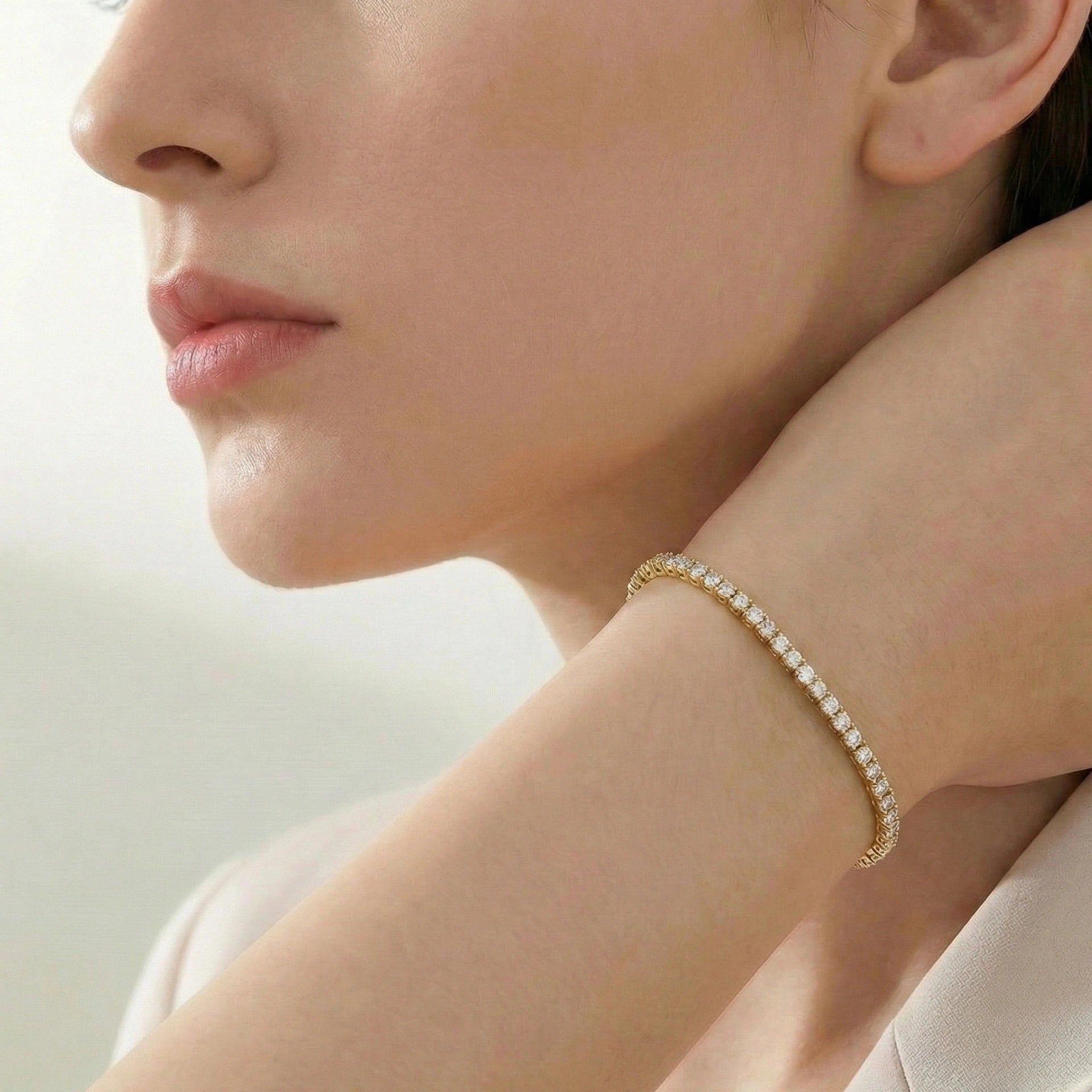 Woman styling a 3mm yellow gold elastic moissanite tennis bangle bracelet on wrist for a refined minimalist look - Sensitive Stones