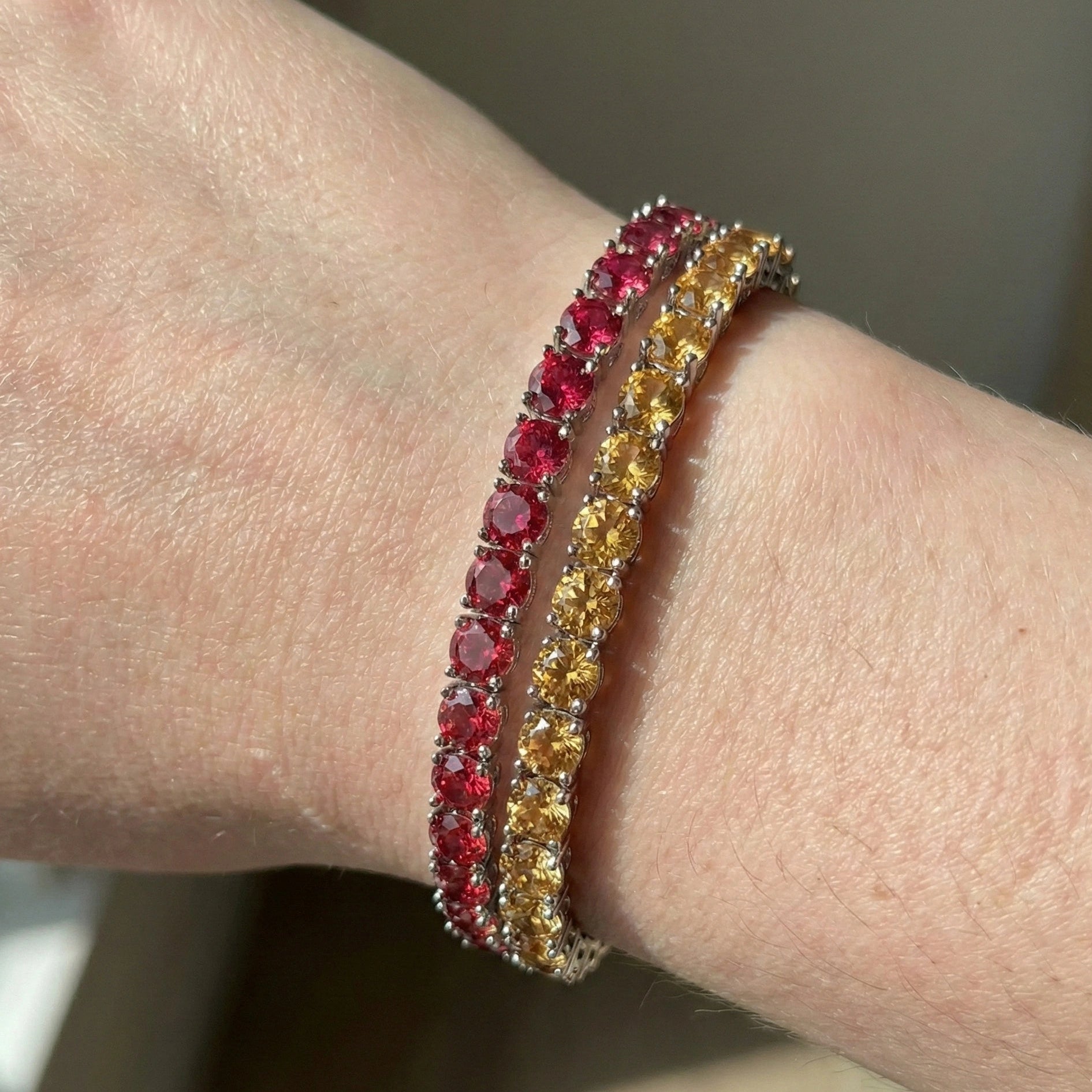 3mm champagne yellow moissanite tennis bracelet stacked with red moissanite tennis bracelet worn on hand under natural lighting – Sensitive Stones