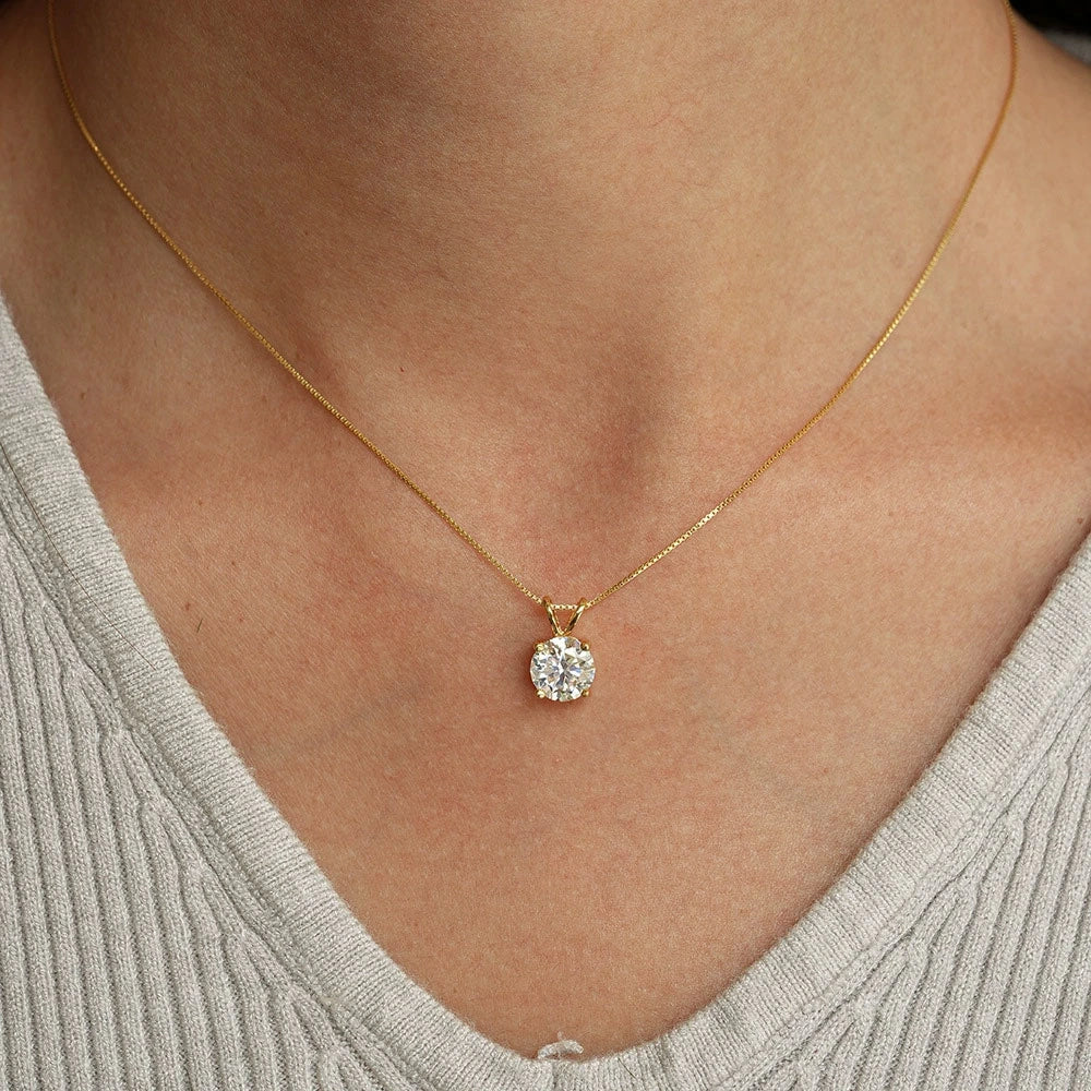 Woman wearing a 4-prong moissanite solitaire necklace set in 925 sterling silver and 18k gold finish - Sensitive Stones