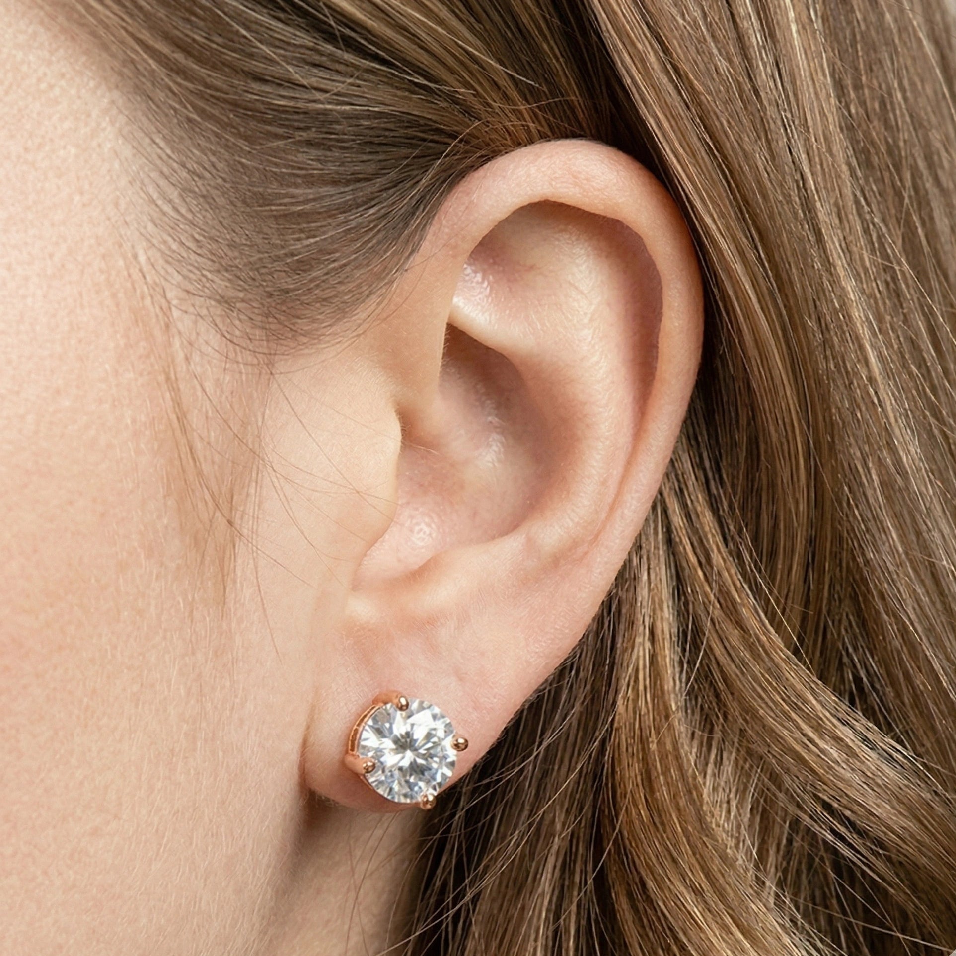 Woman wearing round cut moissanite solitaire stud earring in 4-prong rose gold plating 925 sterling silver setting – Sensitive Stones