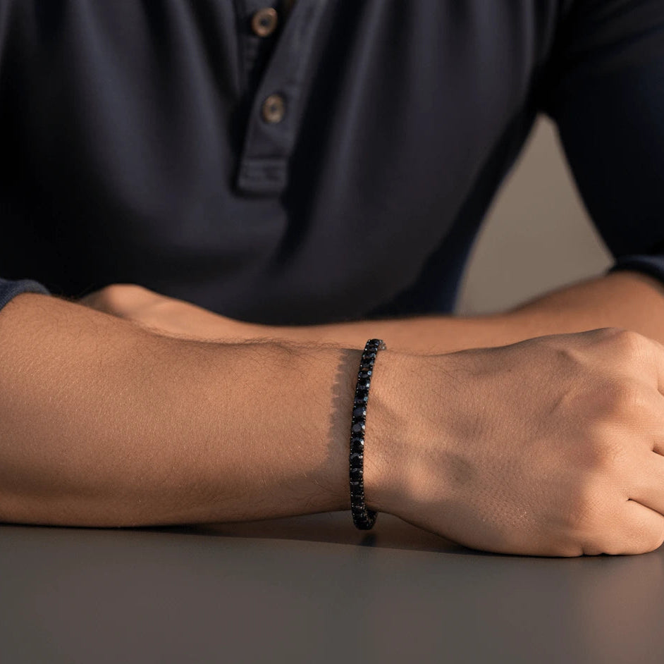 4mm black moissanite tennis bracelet in black gold plating, men’s wrist in navy henley shirt, modern casual style – Sensitive Stones