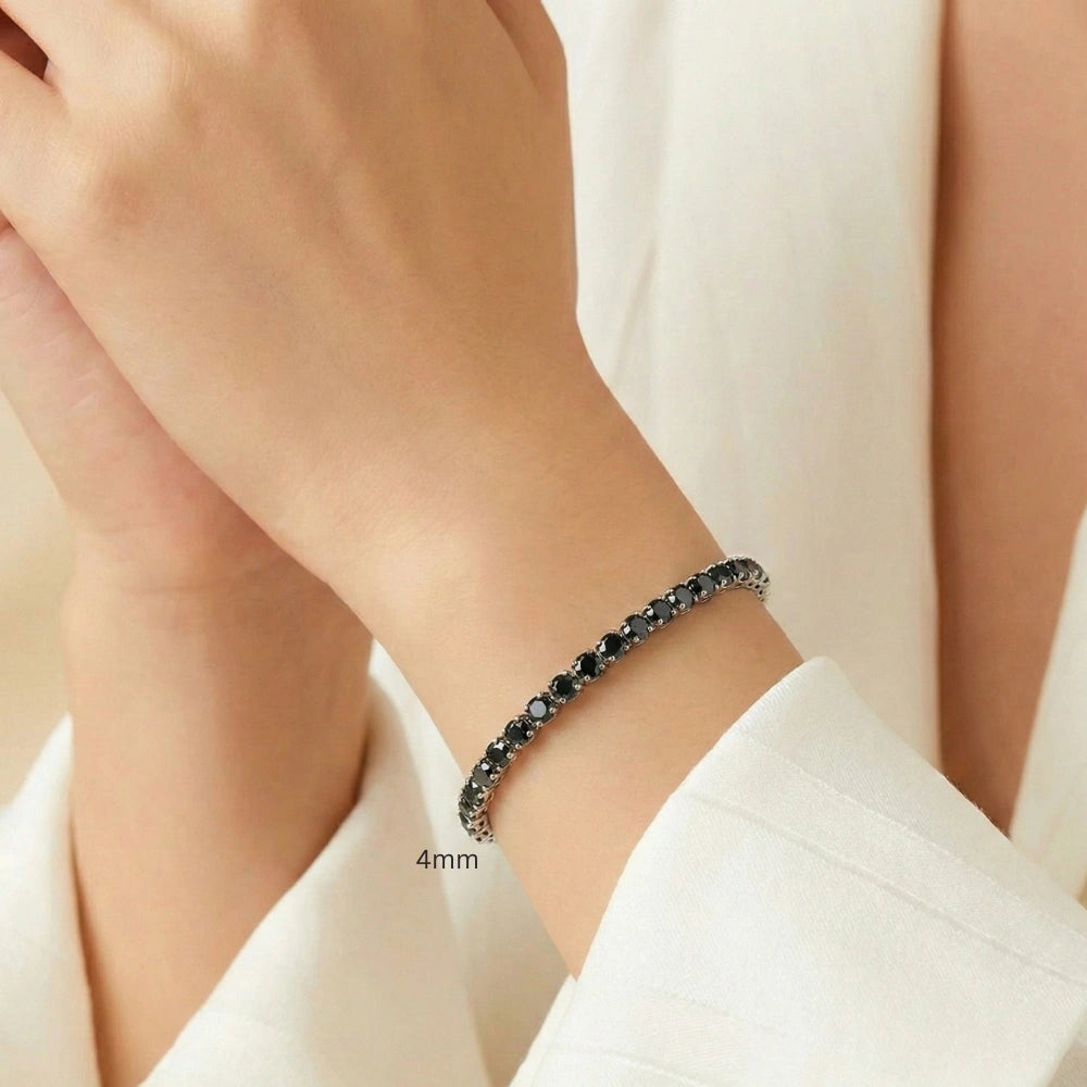 Woman wearing 4 mm black moissanite tennis bracelet in white gold plating, elegant wrist close-up with soft beige background – Sensitive Stones