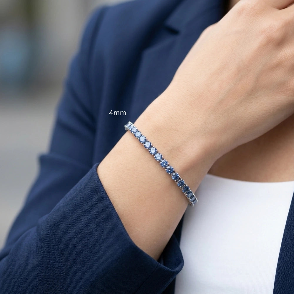 Woman wearing 4mm full blue moissanite tennis bracelet 925 sterling silver round-cut stones dressed in white blouse and blue blazer - Sensitive Stones