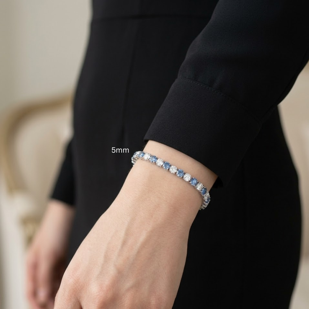 Woman wearing 5mm alternating blue and white moissanite tennis bracelet 925 sterling silver round-cut stones in cream top- Sensitive Stones