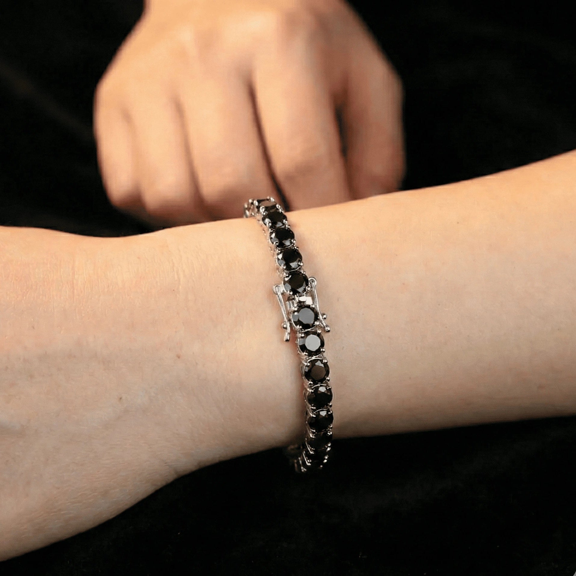 Man wearing 5mm black moissanite tennis bracelet in white gold plating, black outfit, under natural lighting – Sensitive Stones