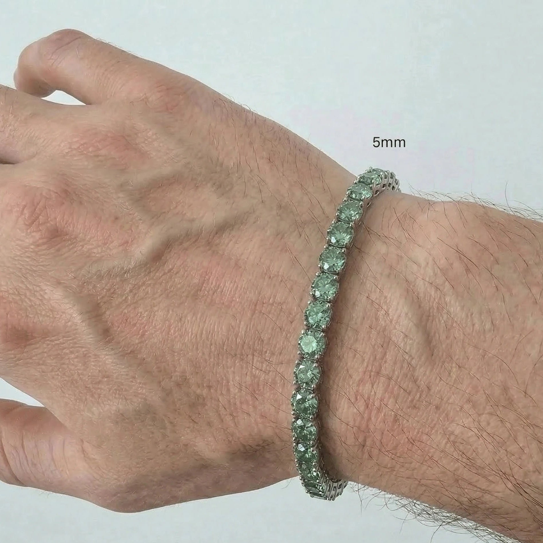 5mm green moissanite tennis bracelet worn on wrist in 925 sterling silver with white gold plating on a man's wrist - Sensitive Stones