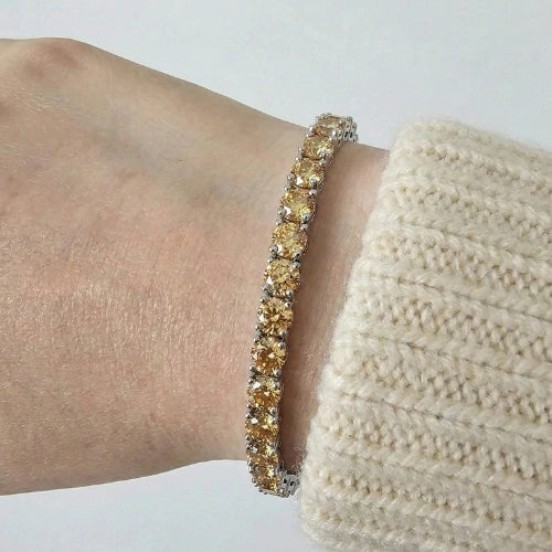Citrine yellow moissanite tennis bracelet on a wrist with a neutral background - Sensitive Stones