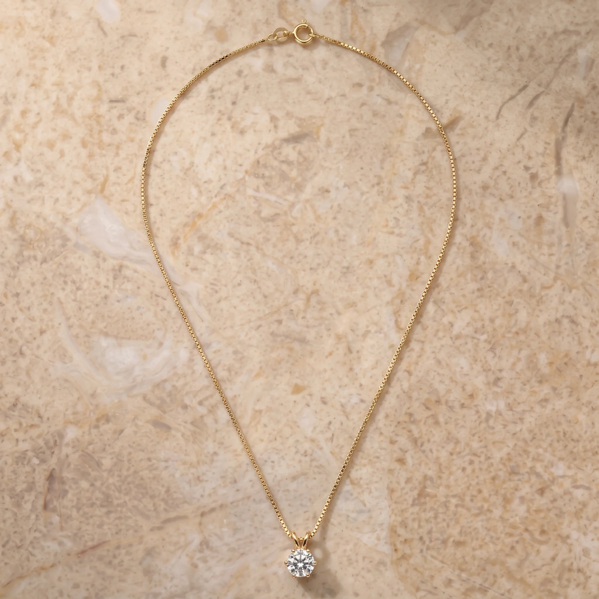 Close-up of the 6-prong moissanite solitaire pendant in a yellow gold finish - Sensitive Stones