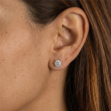 Close up of a woman wearing 6-prong moissanite solitaire stud earrings in 925 sterling silver showing sparkle and brilliance - Sensitive Stones