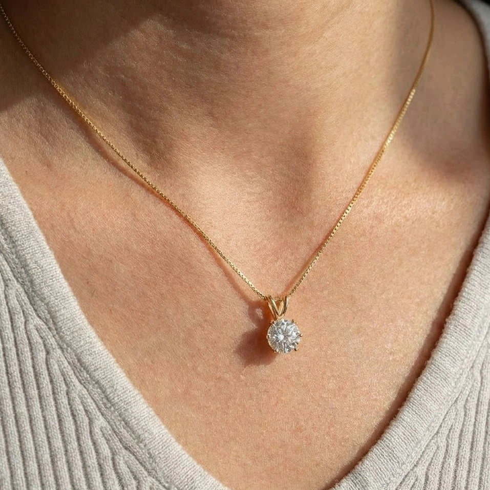 Elegant 6-prong moissanite solitaire pendant necklace in 925 sterling silver with 18K gold plating, featuring brilliant sparkle and diamond-like clarity, worn on body showing product styling - Sensitive Stones