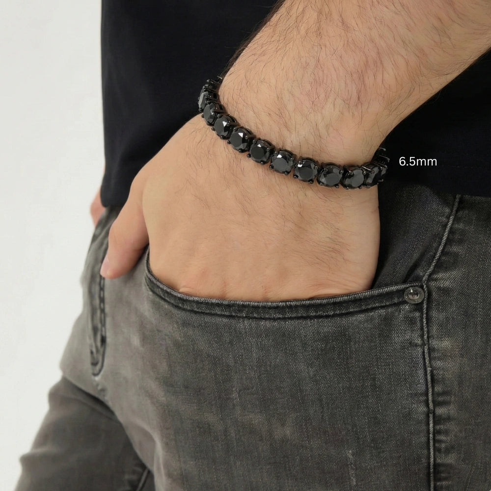 6.5mm black moissanite tennis bracelet in black gold plating, men’s wrist in black simple t-shirt with hand in pocket modern casual style – Sensitive Stones