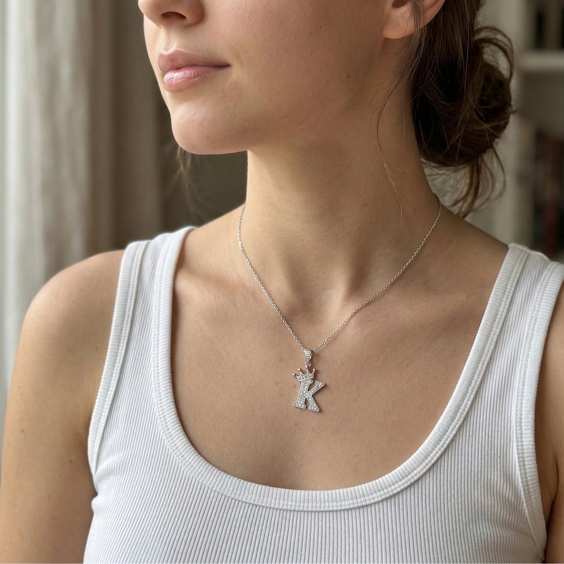 Moissanite crown initial necklace letter K worn on model white tank top indoor natural light - Sensitive Stones
