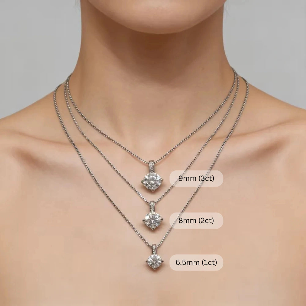 Woman wearing three layered Celeste moissanite solitaire necklaces in sterling silver showing size comparison: 6.5mm 1ct, 8mm 2ct, and 9mm 3ct pendant options