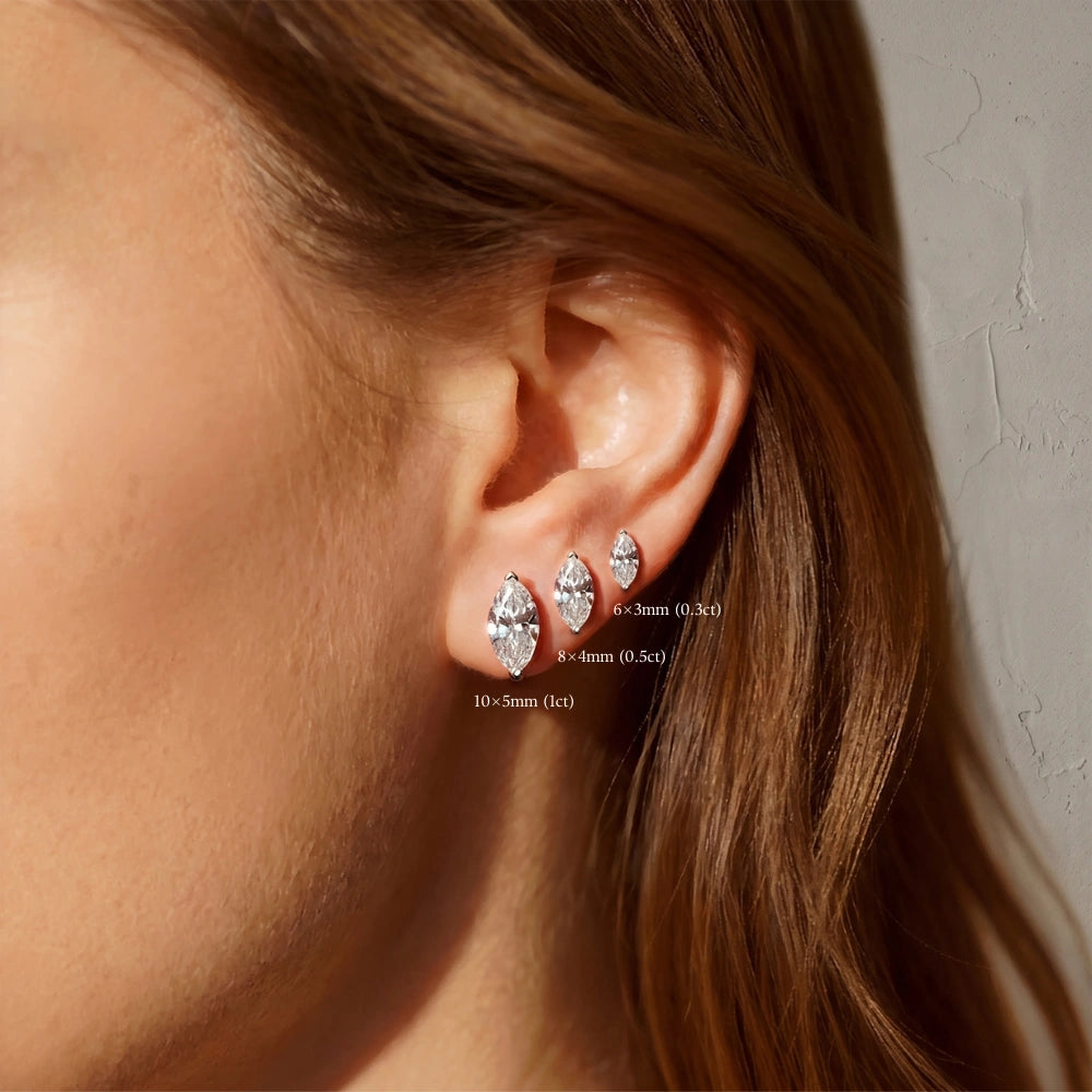 Size guide showing 6 × 3 mm, 8 × 4 mm, and 10 × 5 mm marquise-cut moissanite stud earrings worn on an ear, secured with two V-prongs at each pointed tip.