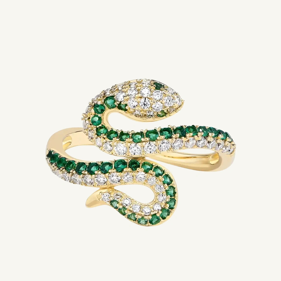 Moissanite coiled snake ring with lab emerald accents on a beige background - Sensitive Stones