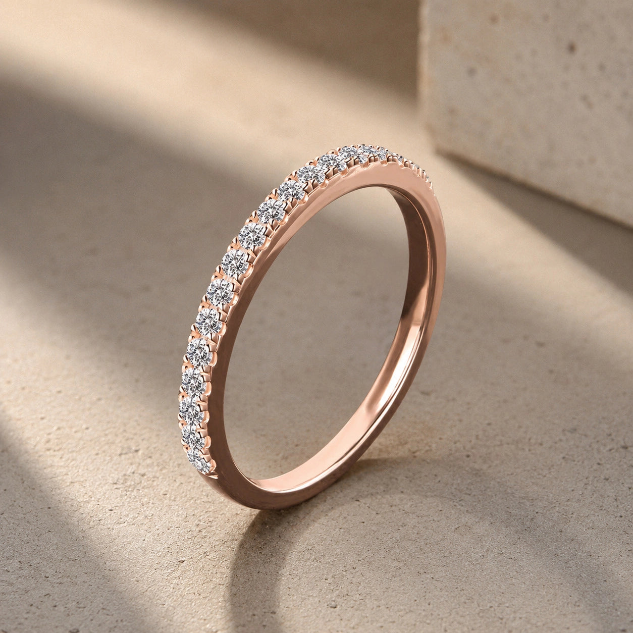 Angled view showing brilliance of 18K rose gold plated silver moissanite ring in a half eternity band design  - Sensitive Stones