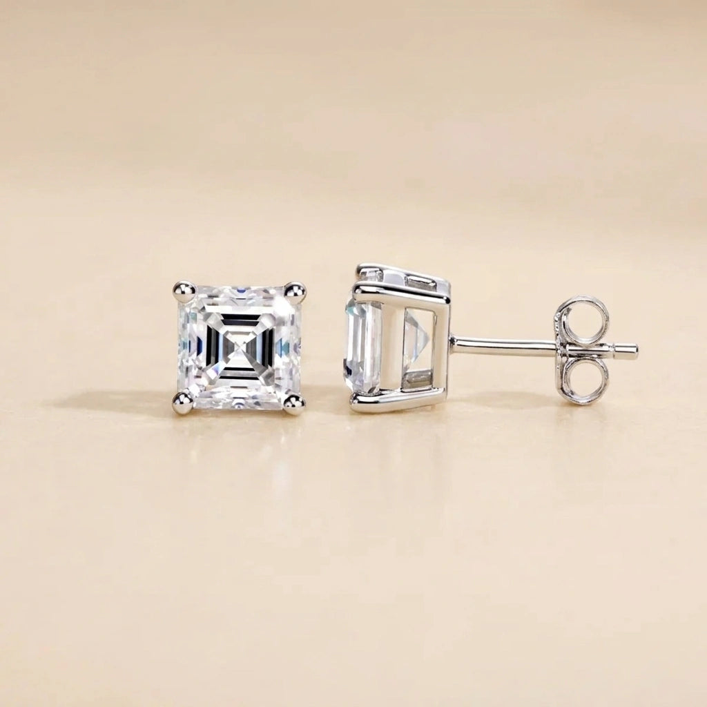Asscher cut moissanite stud earrings in white gold on a cream background, front and side view with butterfly back - Sensitive Stones