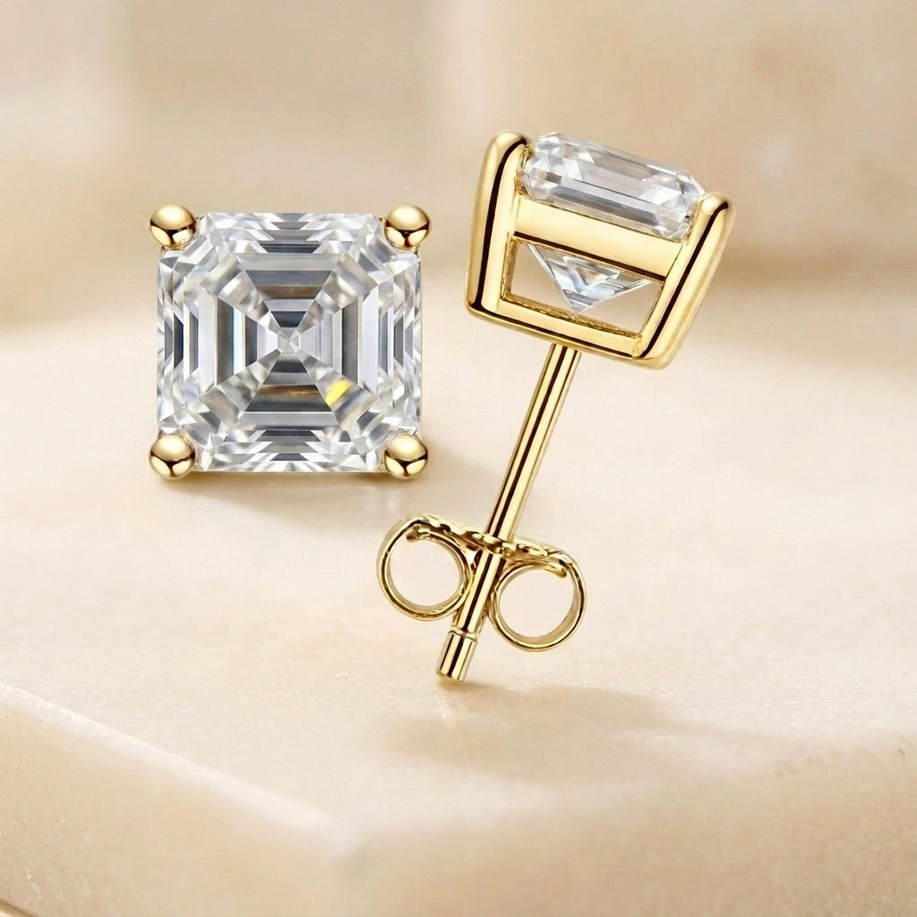 Asscher cut moissanite stud earrings in yellow gold on a cream background, front and side view with push back - Sensitive Stones