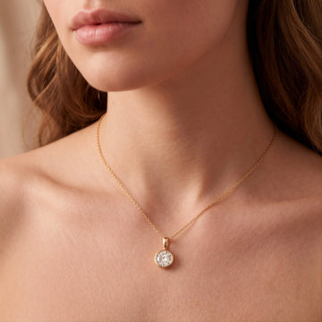 Woman wearing a bezel moissanite solitaire pendant in yellow gold - Sensitive Stones
