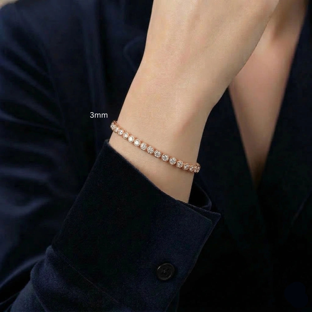 Woman wearing a 3mm bezel moissanite tennis bracelet with D color VVS1 stones in 925 sterling silver and  rose gold finish, styled with dark outfit - Sensitive Stones