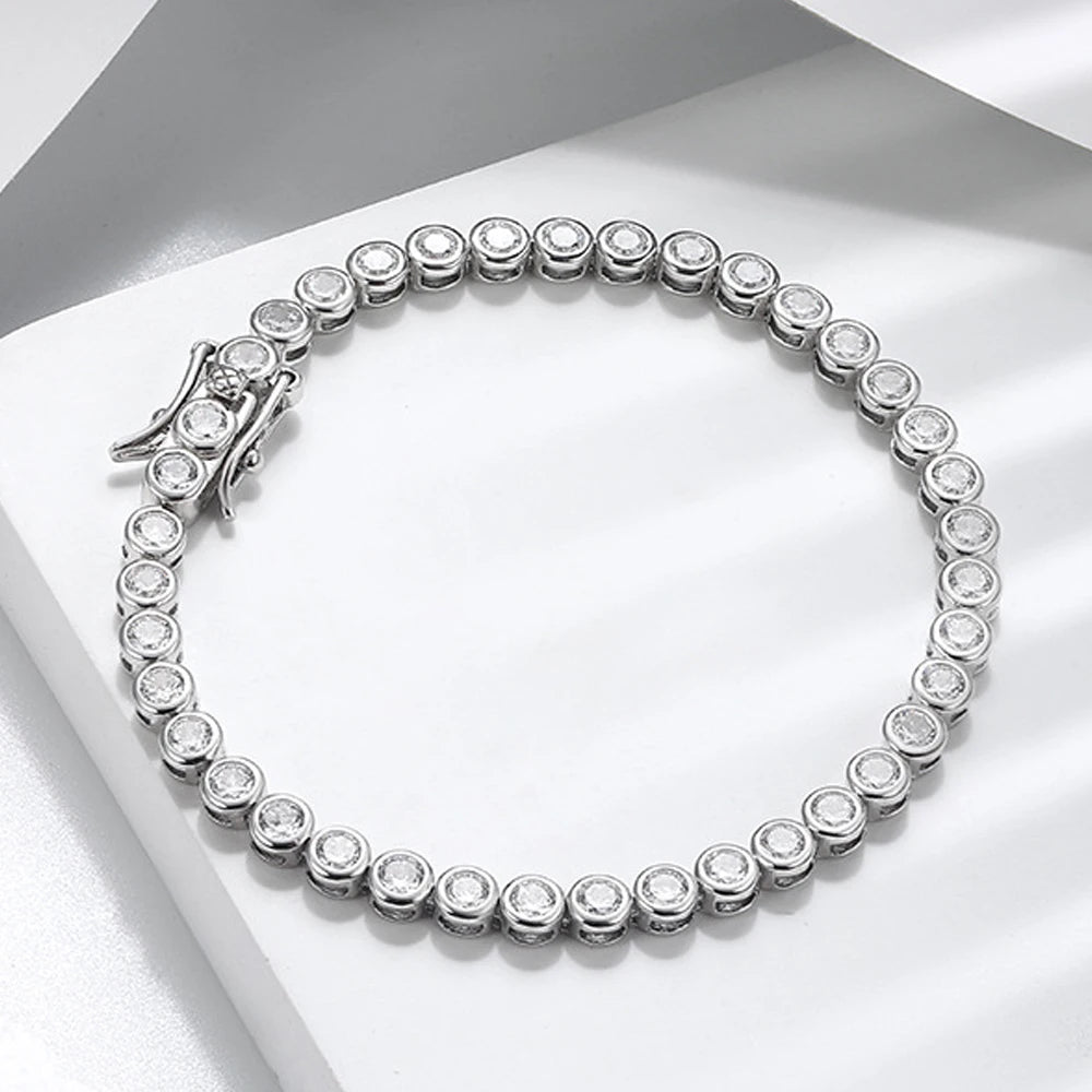Dainty 2mm bezel moissanite tennis bracelet with D color VVS1 stones and double safety clasp in 925 sterling silver on soft white background - Sensitive Stones