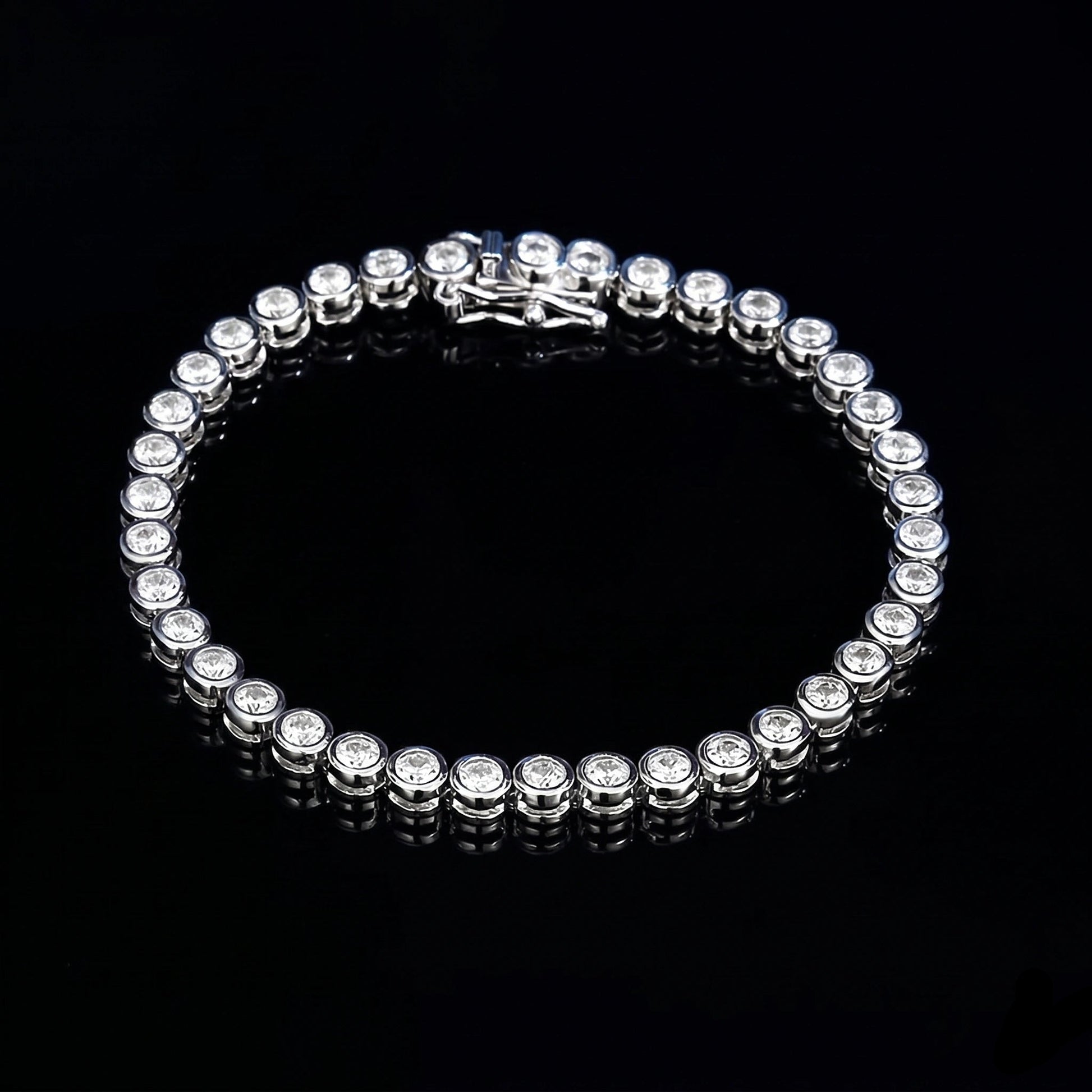 3mm bezel moissanite tennis bracelet with D color VVS1 stones in 925 sterling silver and white gold finish, illuminated against a black background to show fire and brilliance - Sensitive Stones