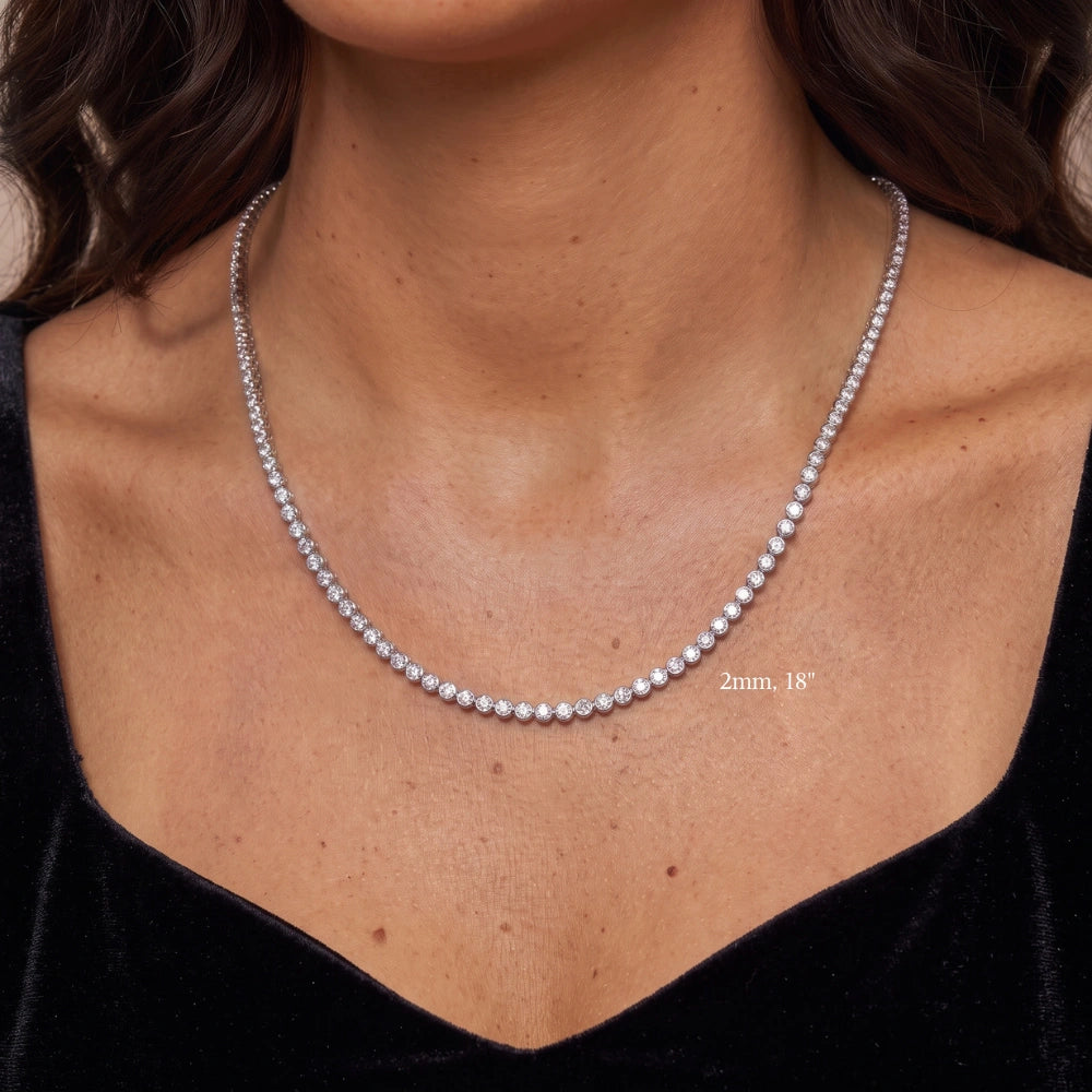 Bezel moissanite tennis necklace with 2mm stones at 18in worn on the upper chest, in 18K white gold plated 925 sterling silver