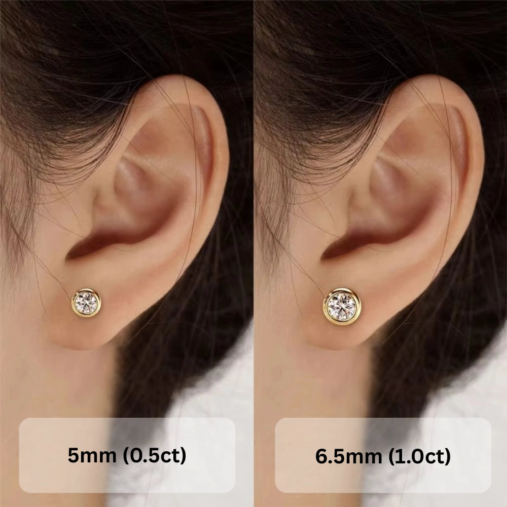 Bezel set moissanite stud earrings in 14K gold plating worn on ear showing 0.5ct and 1ct size comparison - Sensitive Stones