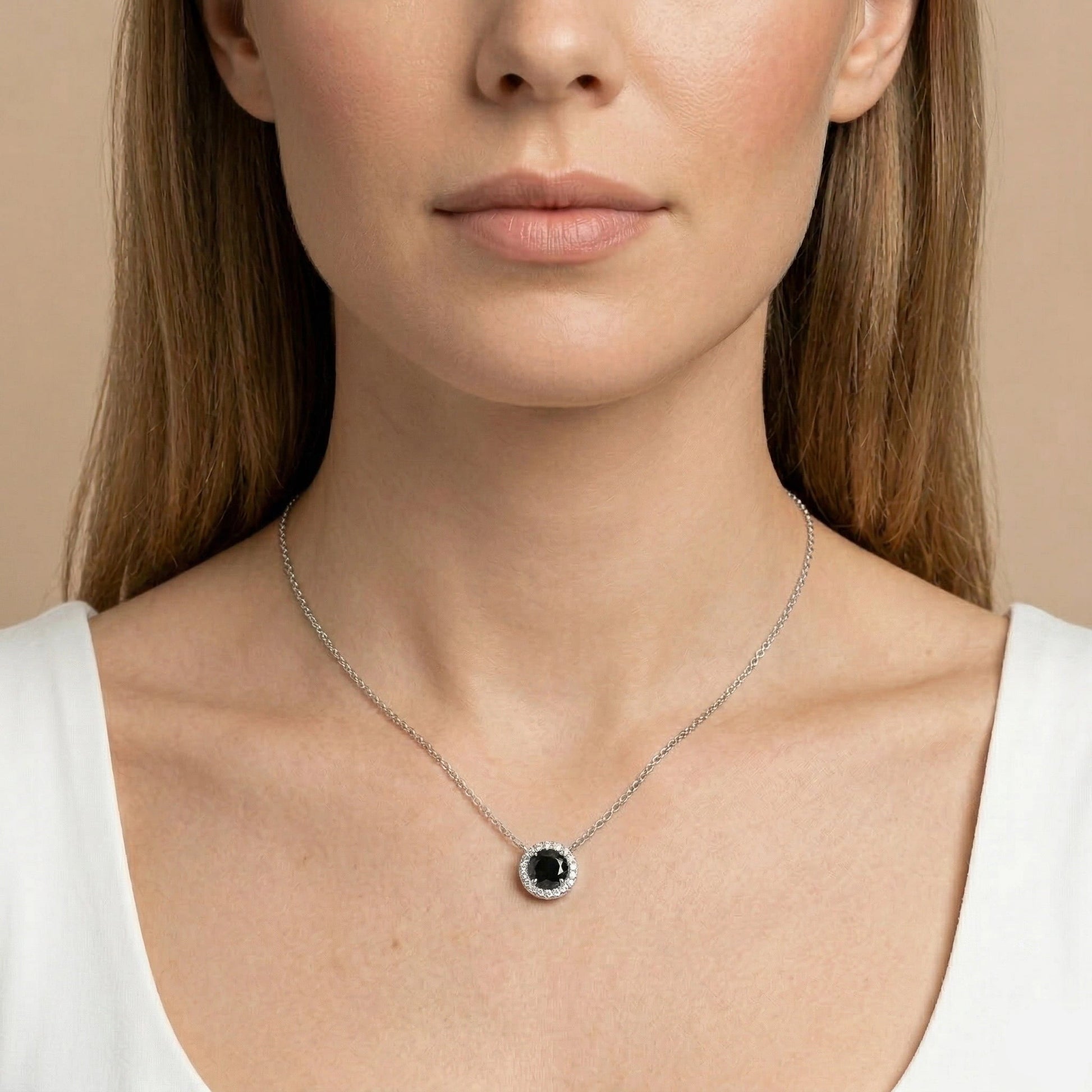 Black moissanite halo pendant necklace 1ct shown on woman’s neck, round black center stone with white halo on delicate sterling silver chain - Sensitive Stones