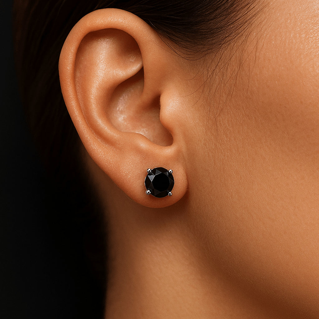 Black moissanite solitaire stud earring on woman’s ear in round cut, minimalist prong setting - Sensitive Stones