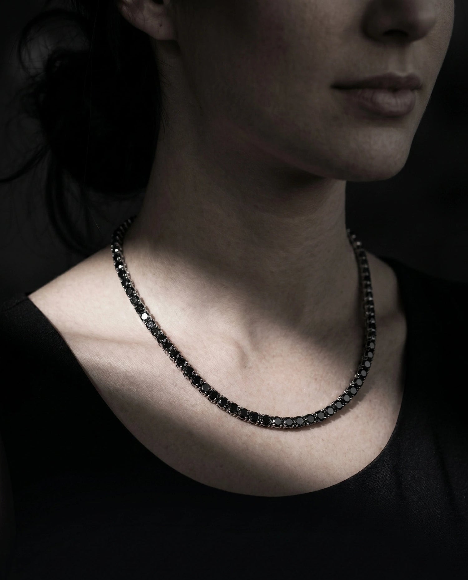 Woman wearing 4mm black moissanite tennis necklace with white gold plating with black top showing elegant everyday style - Sensitive Stones