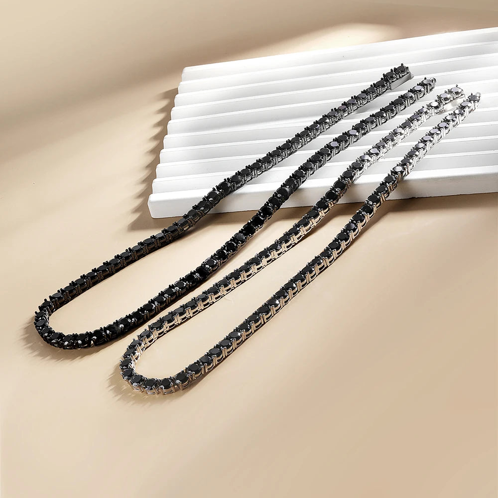 Black moissanite tennis necklace in sterling silver with black gold and white gold color on beige display - Sensitive Stones
